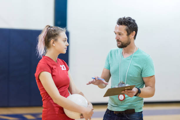 Girls high school volleyball team: coach talking with player